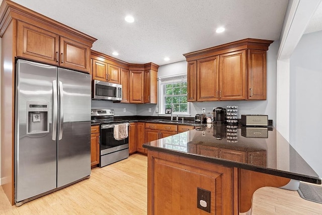 24 Joel Scott Dr, Holden, MA 01520 - kitchen with appliances with stainless steel finishes, a peninsula, brown cabinets, light wood-type flooring, and recessed lighting