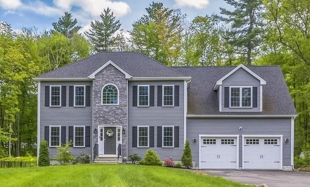82 Sutton St, Uxbridge, MA 01569 - colonial house with a front lawn, a garage, driveway, and stone siding