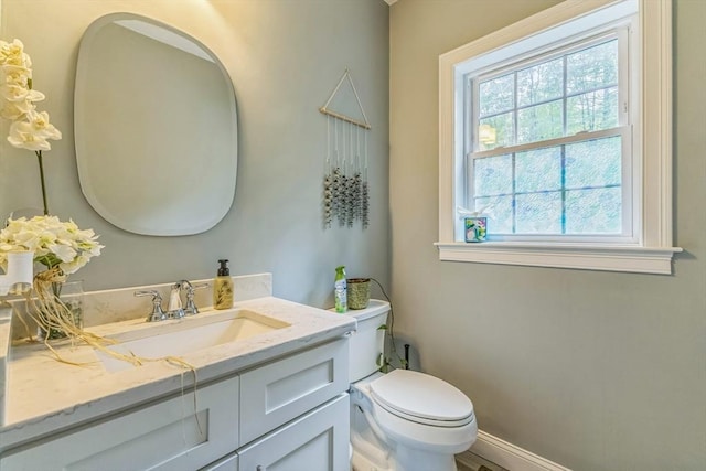 82 Sutton St, Uxbridge, MA 01569 - half bathroom featuring healthy amount of natural light, toilet, vanity, and baseboards