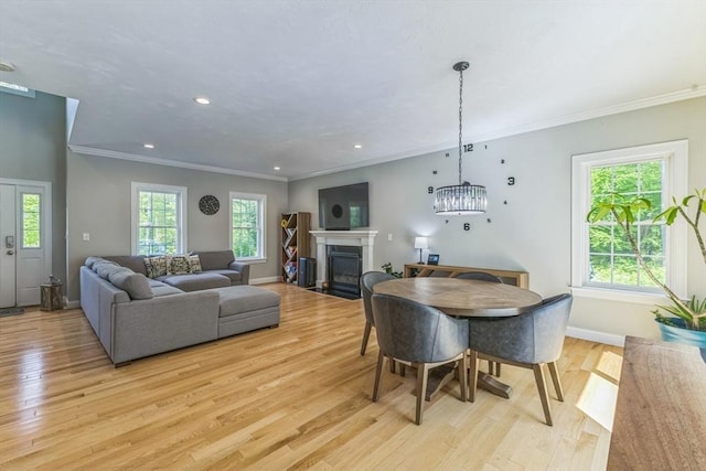 82 Sutton St, Uxbridge, MA 01569 - dining room featuring light wood-style floors, baseboards, a fireplace with flush hearth, ornamental molding, and recessed lighting