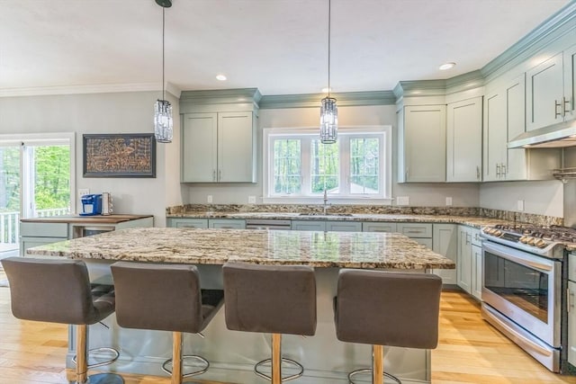 82 Sutton St, Uxbridge, MA 01569 - kitchen featuring gas stove, under cabinet range hood, healthy amount of natural light, a sink, and ornamental molding