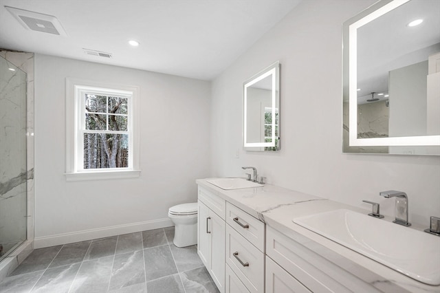 bathroom with vanity, toilet, and a shower with door