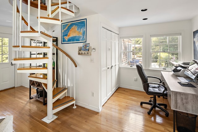 home office with light hardwood / wood-style flooring