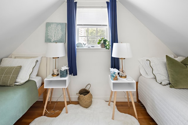 bedroom with dark wood-type flooring and lofted ceiling