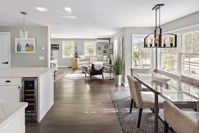 dining space featuring dark hardwood / wood-style floors, an inviting chandelier, wine cooler, and an AC wall unit