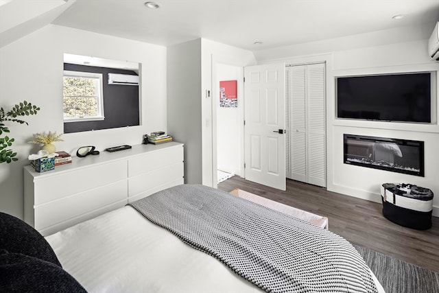 bedroom featuring a closet, a wall mounted air conditioner, and dark hardwood / wood-style floors