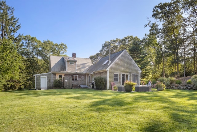 rear view of house featuring a yard and outdoor lounge area