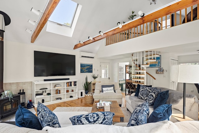 living room with light wood-type flooring, high vaulted ceiling, a wall mounted AC, a skylight, and a wood stove