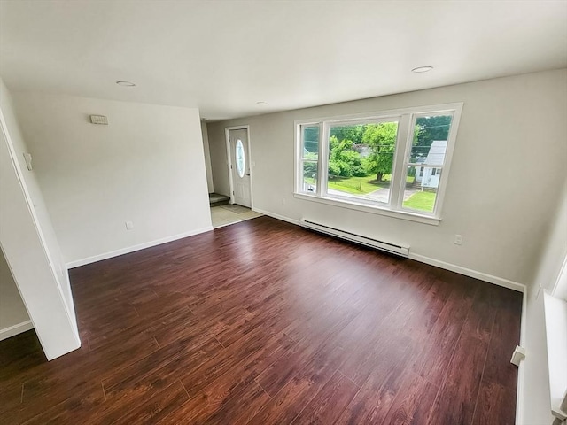 unfurnished room featuring baseboard heating and dark wood-type flooring