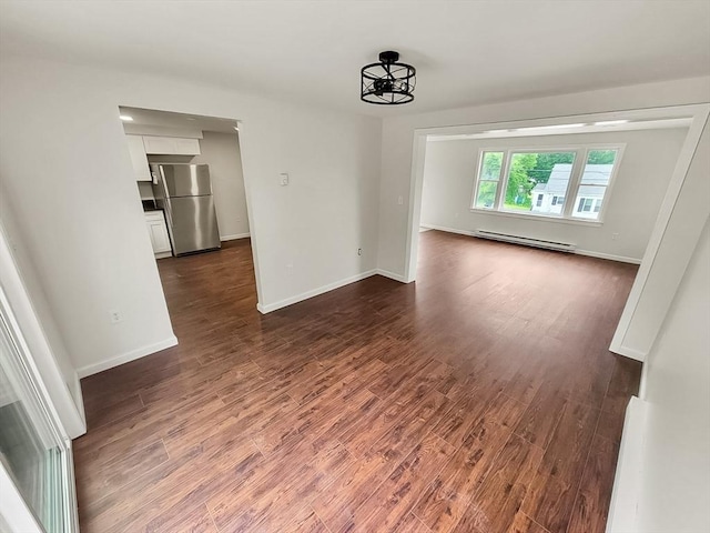 unfurnished living room with dark hardwood / wood-style flooring, a baseboard radiator, and a notable chandelier