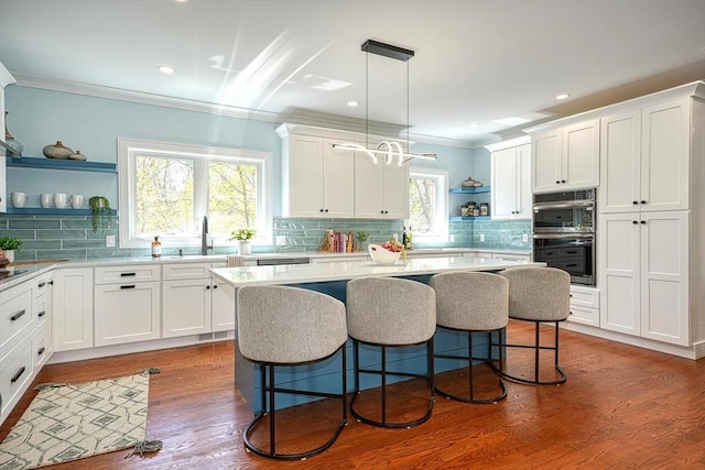 147 Ridge St, Arlington, MA 02474 - kitchen featuring open shelves, stainless steel double oven, a sink, a kitchen breakfast bar, and tasteful backsplash