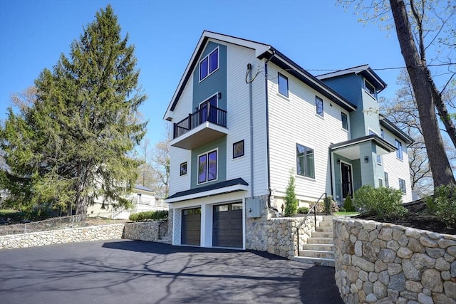 147 Ridge St, Arlington, MA 02474 - view of front of house with an attached garage, aphalt driveway, a balcony, and stairway