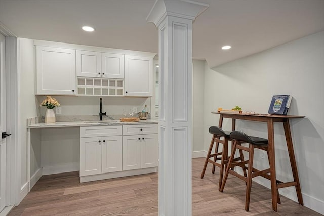 147 Ridge St, Arlington, MA 02474 - bar with baseboards, a sink, light wood finished floors, and decorative columns