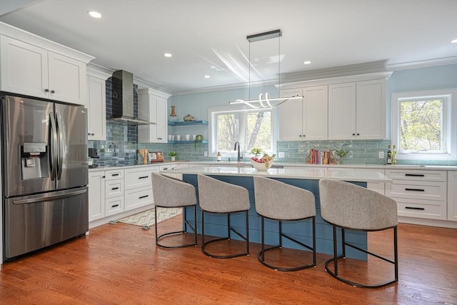 147 Ridge St, Arlington, MA 02474 - kitchen with stainless steel fridge, tasteful backsplash, wall chimney exhaust hood, and a healthy amount of sunlight