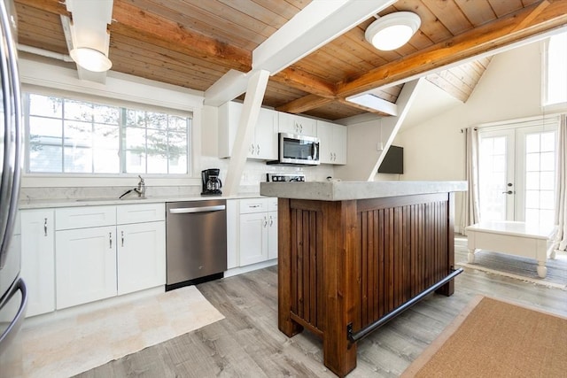 kitchen featuring plenty of natural light, stainless steel appliances, light hardwood / wood-style floors, and white cabinets