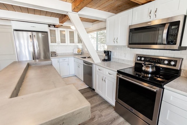 kitchen with backsplash, appliances with stainless steel finishes, and white cabinets