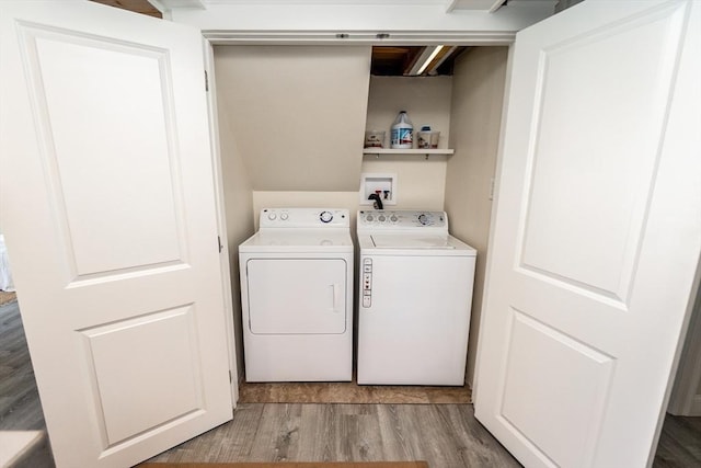 clothes washing area with washing machine and dryer and light hardwood / wood-style floors