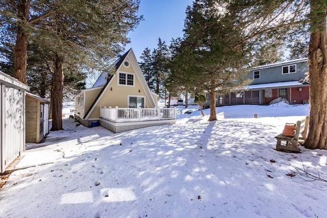 snow covered house featuring a deck