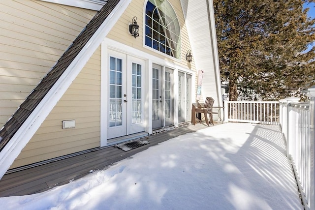 snow covered property entrance featuring french doors