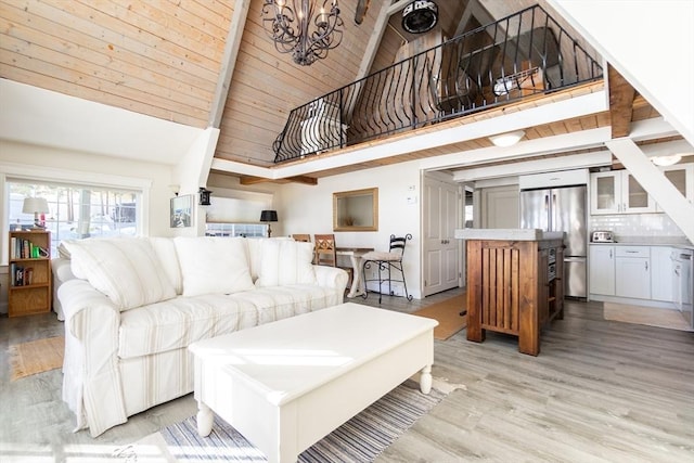 living room with high vaulted ceiling, a notable chandelier, wooden ceiling, beamed ceiling, and light wood-type flooring