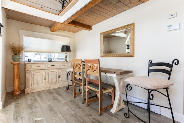 dining space with beamed ceiling, light wood-type flooring, and wooden ceiling