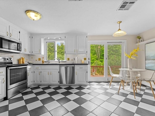 769 Edgell Rd, Framingham, MA 01701 - kitchen with stainless steel appliances, light flooring, backsplash, and white cabinets