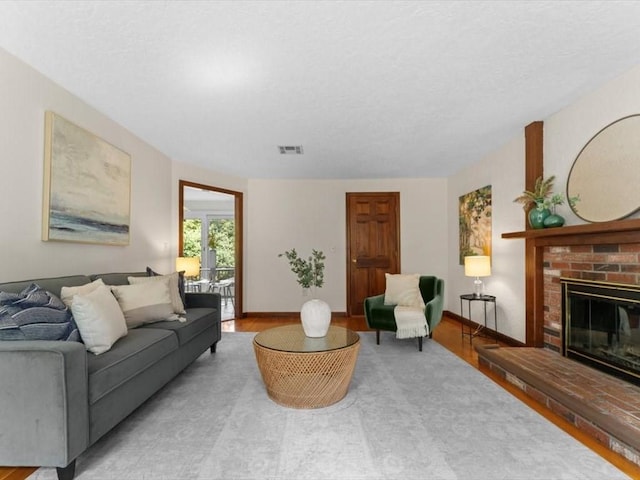 769 Edgell Rd, Framingham, MA 01701 - living area with wood finished floors, a brick fireplace, and baseboards