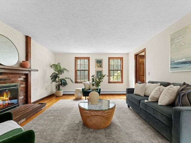 769 Edgell Rd, Framingham, MA 01701 - living room with a baseboard radiator, a brick fireplace, wood finished floors, a textured ceiling, and a baseboard heating unit