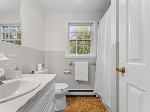 769 Edgell Rd, Framingham, MA 01701 - full bath with baseboard heating, tile walls, vanity, plenty of natural light, and toilet