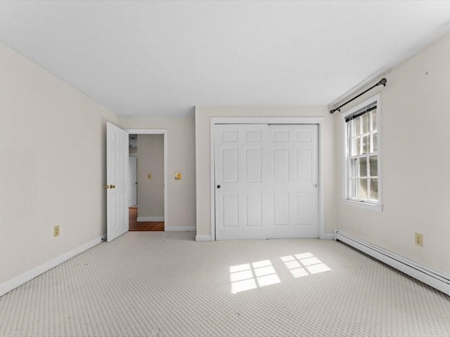 769 Edgell Rd, Framingham, MA 01701 - unfurnished bedroom featuring a baseboard heating unit, light colored carpet, a closet, and baseboards