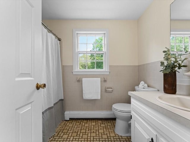 769 Edgell Rd, Framingham, MA 01701 - full bathroom with baseboard heating, tile walls, toilet, vanity, and wainscoting