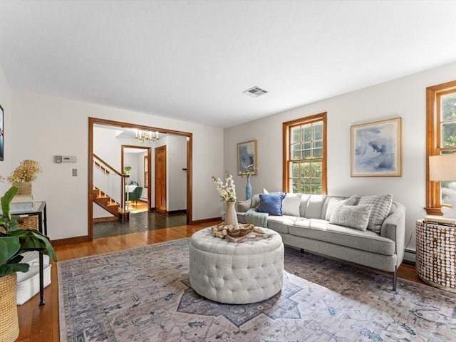 769 Edgell Rd, Framingham, MA 01701 - living area featuring a chandelier, stairs, wood finished floors, baseboards, and baseboard heating