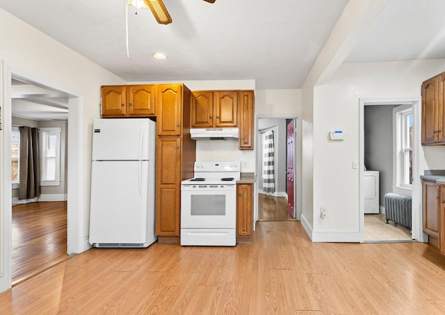 kitchen featuring radiator, white appliances, light hardwood / wood-style flooring, ceiling fan, and washer / dryer