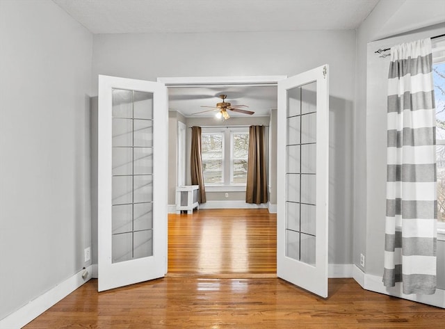 spare room featuring hardwood / wood-style flooring, french doors, and ceiling fan