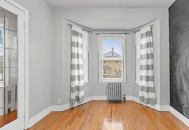 spare room with radiator and light hardwood / wood-style floors