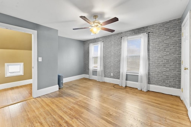 interior space featuring radiator, brick wall, and light wood-type flooring