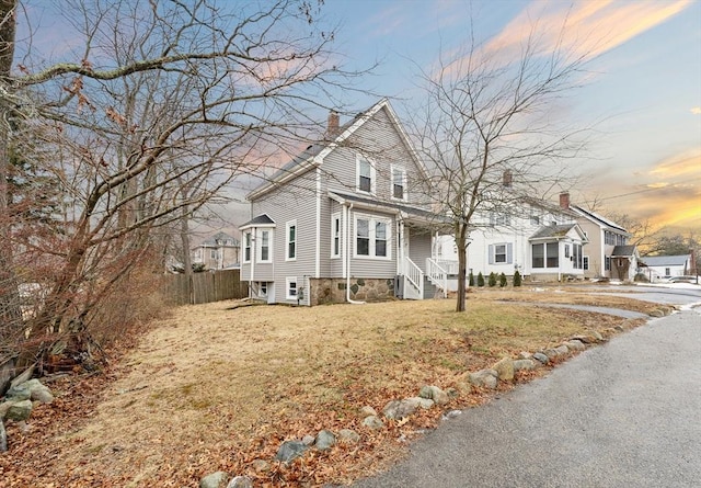 property exterior at dusk with a lawn