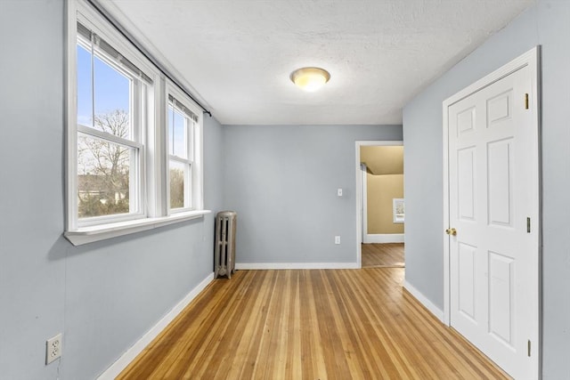 spare room with radiator and light hardwood / wood-style floors