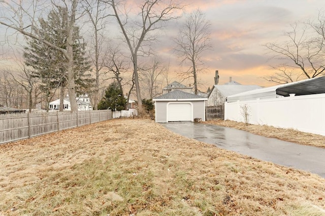 yard at dusk with an outbuilding and a garage