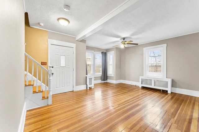 entrance foyer with hardwood / wood-style floors, a healthy amount of sunlight, radiator heating unit, and a textured ceiling