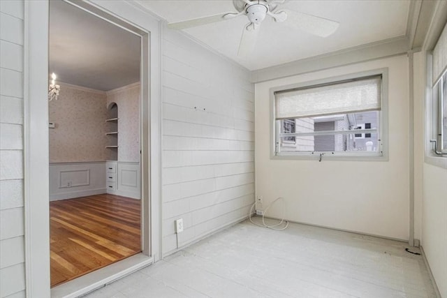 unfurnished room featuring ceiling fan and ornamental molding