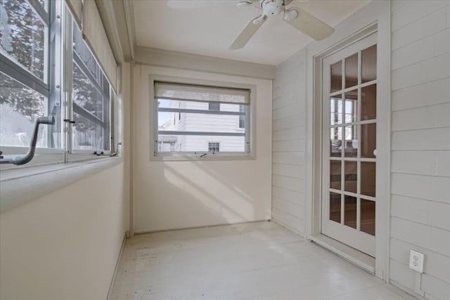 unfurnished sunroom featuring ceiling fan