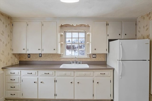 kitchen with sink, white cabinets, and white fridge