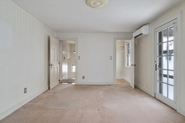 carpeted spare room with a wall unit AC