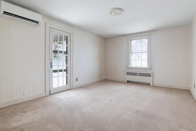 carpeted spare room with radiator heating unit and a wall mounted air conditioner