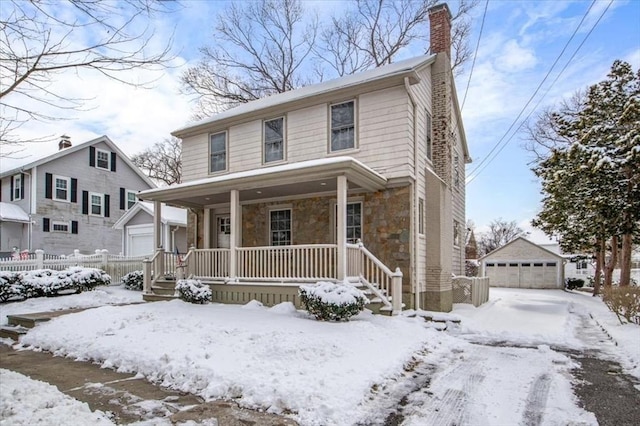 front of property with a garage, an outbuilding, and a porch