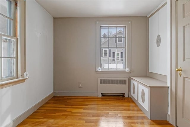 doorway to outside with light wood-type flooring and radiator