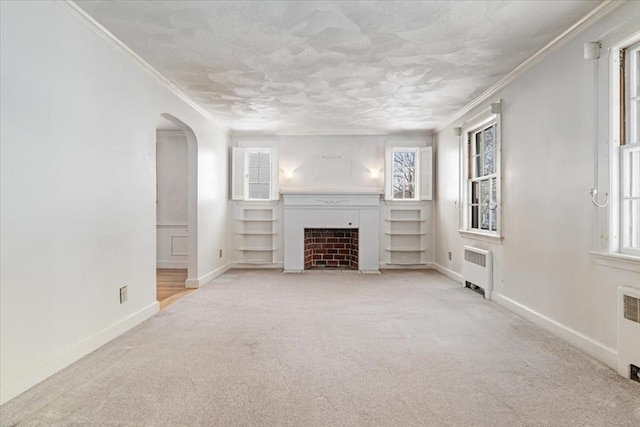 unfurnished living room featuring crown molding, a healthy amount of sunlight, light colored carpet, and radiator