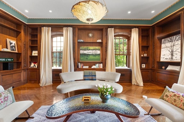 living area featuring built in features and crown molding