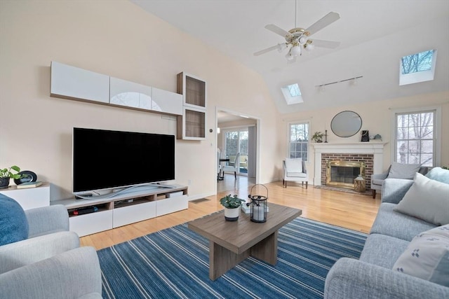 living room featuring a fireplace, lofted ceiling, ceiling fan, wood finished floors, and baseboards